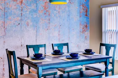 a dining room table with chairs and a blue wall at Fascinating Lake View With Private Pool And Game-Room, Near Disney!! in Kissimmee