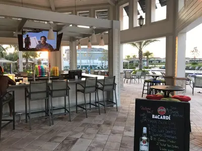 a restaurant with a bar with chairs and a tv at B - New 4 Bedroom Home - 5 Miles to Disney - Free Water Park - Private Pool in Kissimmee