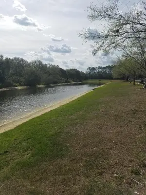 a grassy field next to a river at InTown Suites Extended Stay Select Orlando FL - UCF in Orlando