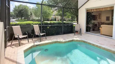 a swimming pool with two chairs and a house at Silver Palms in Kissimmee