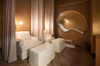 a room with a mirror and a white chair and a table at ette luxury hotel & spa - Near Disney Theme Parks in Orlando