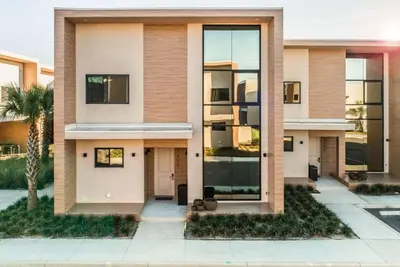 a house with glass windows and a palm tree at Magic Village Views Trademark Collection by Wyndham in Orlando