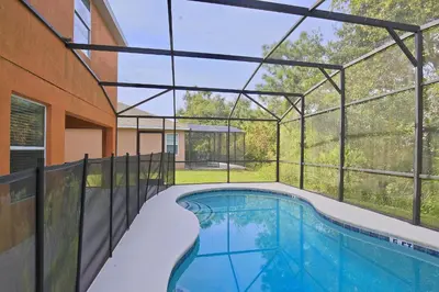 a swimming pool inside of a house with a building at Spectacular big house, 4 Bedrooms, private pool in Kissimmee
