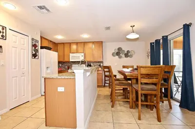 a kitchen and dining room with a table and chairs at Spectacular big house, 4 Bedrooms, private pool in Kissimmee