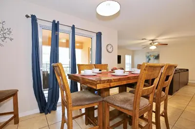 a dining room with a wooden table and chairs at Spectacular big house, 4 Bedrooms, private pool in Kissimmee