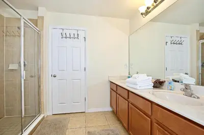 a bathroom with a sink and a shower and a mirror at Spectacular big house, 4 Bedrooms, private pool in Kissimmee