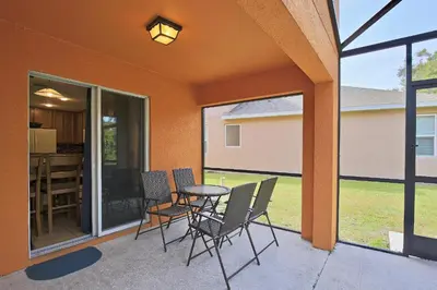 a patio with chairs and a table on a porch at Spectacular big house, 4 Bedrooms, private pool in Kissimmee