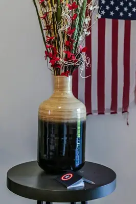 a vase with flowers sitting on a table next to a flag at H - New 2 Bedroom Condo - 5 Miles to Disney - Free Water Park in Kissimmee