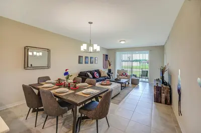 a dining room and living room with a table and chairs at H - New 2 Bedroom Condo - 5 Miles to Disney - Free Water Park in Kissimmee