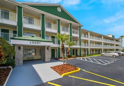a view of a hotel with a parking lot at HomeTowne Studios by Red Roof Orlando - UCF Area in Orlando