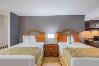 a hotel room with two beds and a kitchen at OYO Hotel Orlando Airport in Orlando