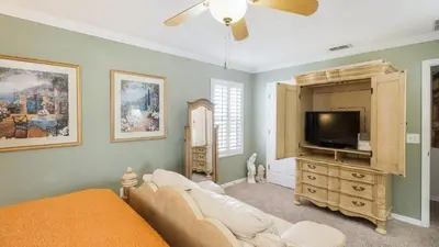 a living room with a couch and a flat screen tv at Mickeys Maingate Mansion in Kissimmee