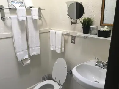 a bathroom with a toilet and a sink and towels at Park Plaza Hotel Orlando - Winter Park in Orlando