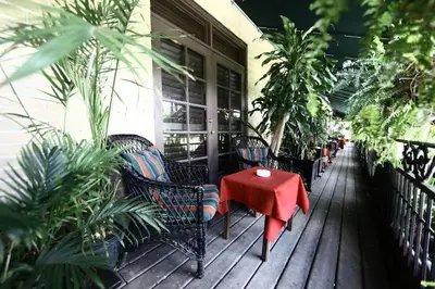 a porch with a red table and chairs and plants at Park Plaza Hotel Orlando - Winter Park in Orlando