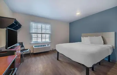 a bedroom with a large bed and a television at Extended Stay America Select Suites - Orlando - Sanford - Airport in Sanford