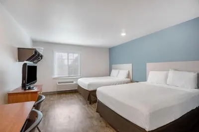 a hotel room with two beds and a desk at Extended Stay America Select Suites - Orlando - Sanford - Airport in Sanford