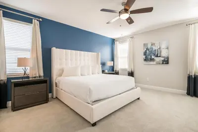 a bedroom with a white bed and a blue wall at Fabulous Home With Air Hockey, Media Room And Waterpark & Resort Access Near Disney At Encore Resorts Reunion - 290Fl in Kissimmee