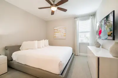 a bedroom with a white bed and a ceiling fan at Fabulous Home With Air Hockey, Media Room And Waterpark & Resort Access Near Disney At Encore Resorts Reunion - 290Fl in Kissimmee