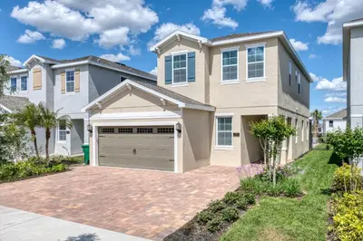 a house with a driveway and a garage at Welcoming Home With Air Hockey Table And Waterpark & Resort Access Near Disney At Encore Resorts Reunion - 321Bu in Kissimmee