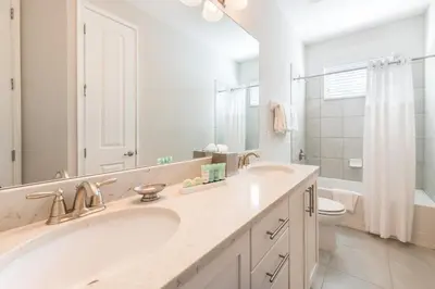 a bathroom with a sink and a toilet and a mirror at Cozy Home With Private Pool, Air Hockey Table And Themed Room Near Disney With Waterpark & Resort Access At Encore Resort - 7458Mr in Kissimmee