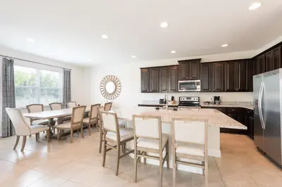 a large kitchen with a table and chairs at Lovely Home With Private Pool And Air Hockey Table Near Disney With Waterpark & Resort Access At Encore Resort - 7467Mr in Kissimmee