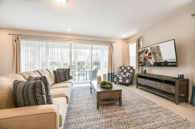 a living room with a couch and a flat screen tv at Cozy Home With Private Pool, Air Hockey Table Near Disney With Waterpark & Resort Access At Encore Resort - 7702Gr in Kissimmee