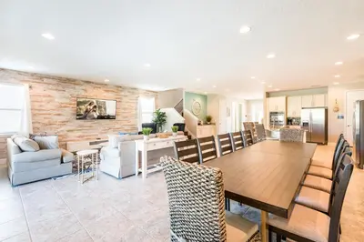 a dining room and living room with a table and chairs at Spectacular Home With Theater, Theme Rooms Near Disney With Waterpark & Resort Access At Encore Resort - 7734Gr in Kissimmee