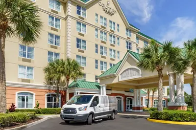 a white van parked in front of a hotel at Country Inn & Suites by Radisson, Orlando Airport, FL in Orlando