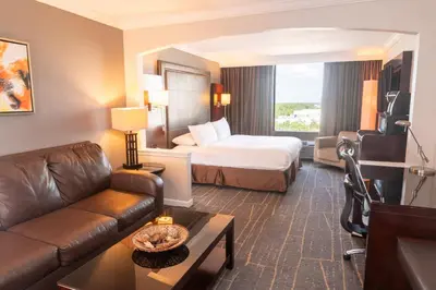 a hotel room with a bed and a couch at Holiday Inn Orlando East-UCF Area by IHG in Orlando
