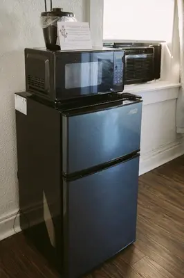 a microwave sitting on top of a refrigerator at Hunter Arms Hotel in Saint Cloud