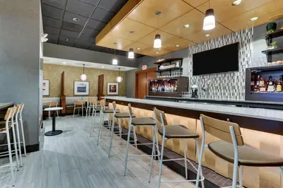a bar in a restaurant with chairs and a tv at Drury Inn & Suites Orlando near Universal Orlando Resort in Orlando