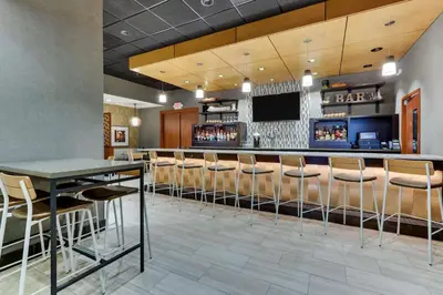 a bar with stools in a hotel room at Drury Inn & Suites Orlando near Universal Orlando Resort in Orlando