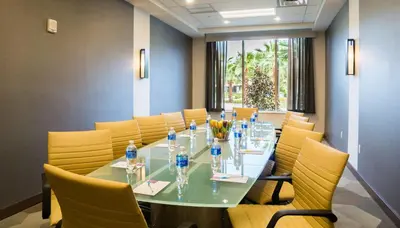 a conference room with a long table and yellow chairs at Hyatt Place Orlando/Lake Buena Vista in Orlando
