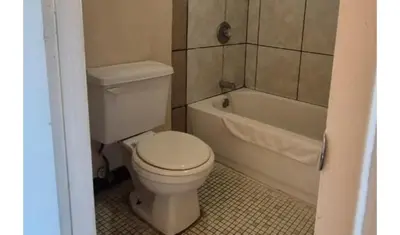a bathroom with a toilet and a bath tub at Central Motel Kissimmee Near Disney World in Kissimmee