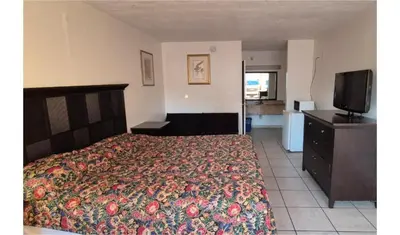a bedroom with a bed and a flat screen tv at Central Motel Kissimmee Near Disney World in Kissimmee