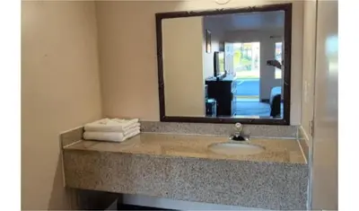 a bathroom counter with a sink and a mirror at Central Motel Kissimmee Near Disney World in Kissimmee