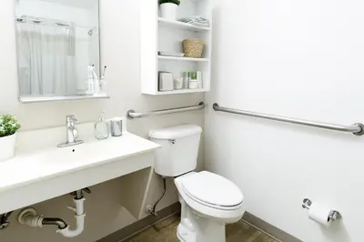 a bathroom with a white toilet and a sink at InTown Suites Extended Stay Orlando FL - Universal in Orlando
