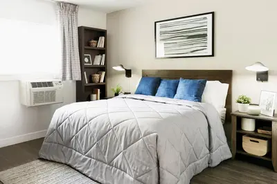 a bedroom with a large bed with blue pillows at InTown Suites Extended Stay Select Orlando FL - Lee Rd in Orlando