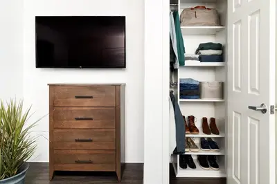 a closet with a television and a dresser with shoes at InTown Suites Extended Stay Select Orlando FL - Lee Rd in Orlando