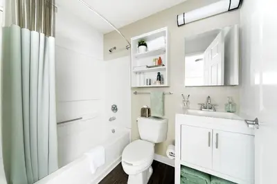 a white bathroom with a toilet and a sink at InTown Suites Extended Stay Orlando FL - South in Orlando