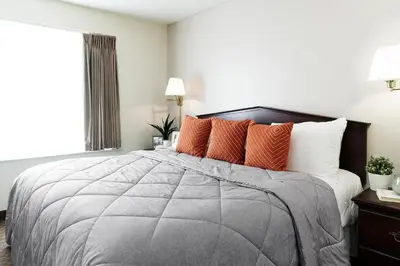 a bedroom with a large bed with orange pillows at InTown Suites Extended Stay Orlando FL - South in Orlando