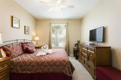 a bedroom with a bed and a flat screen tv at Fantastic Condo - 2 Miles from Disney Pool View Windsor Hills in Orlando