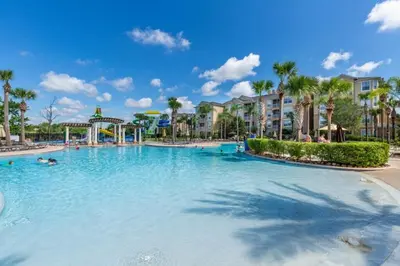 a large swimming pool at a resort with palm trees at Fantastic Condo - 2 Miles from Disney Pool View Windsor Hills in Orlando