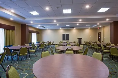 a conference room with tables and chairs and a podium at Holiday Inn Express Hotel & Suites Orlando East-UCF Area by IHG in Orlando