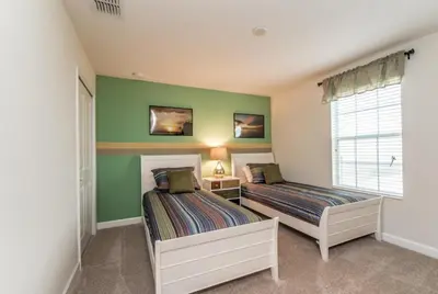 two beds in a room with green walls at Enchanting Escape Private Pool SPA Games Room in Orlando