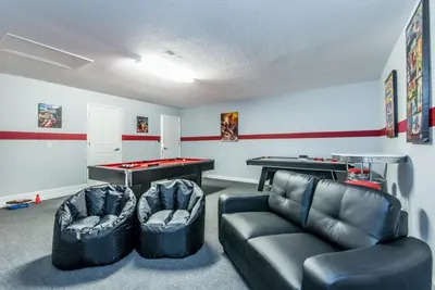 a living room with a couch and a ping pong table at Enchanting Escape Private Pool SPA Games Room in Orlando