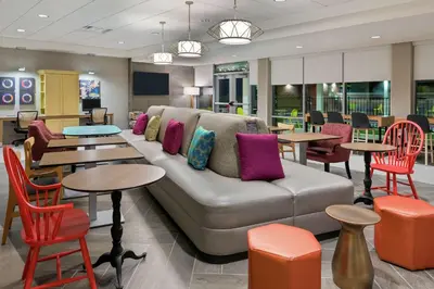 a lobby with a couch and tables and chairs at Home2 Suites By Hilton Orlando Near UCF in Orlando