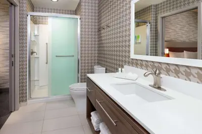 a bathroom with a sink and a toilet and a mirror at Home2 Suites By Hilton Orlando Near UCF in Orlando