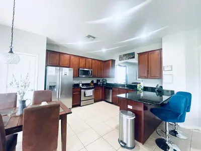 a kitchen with wooden cabinets and a table and chairs at My Disney Castle in Orlando