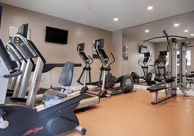 a gym with a bunch of treadmills and machines at The Point Hotel & Suites - 503 Luxury - Pool view - Close to Universal in Orlando